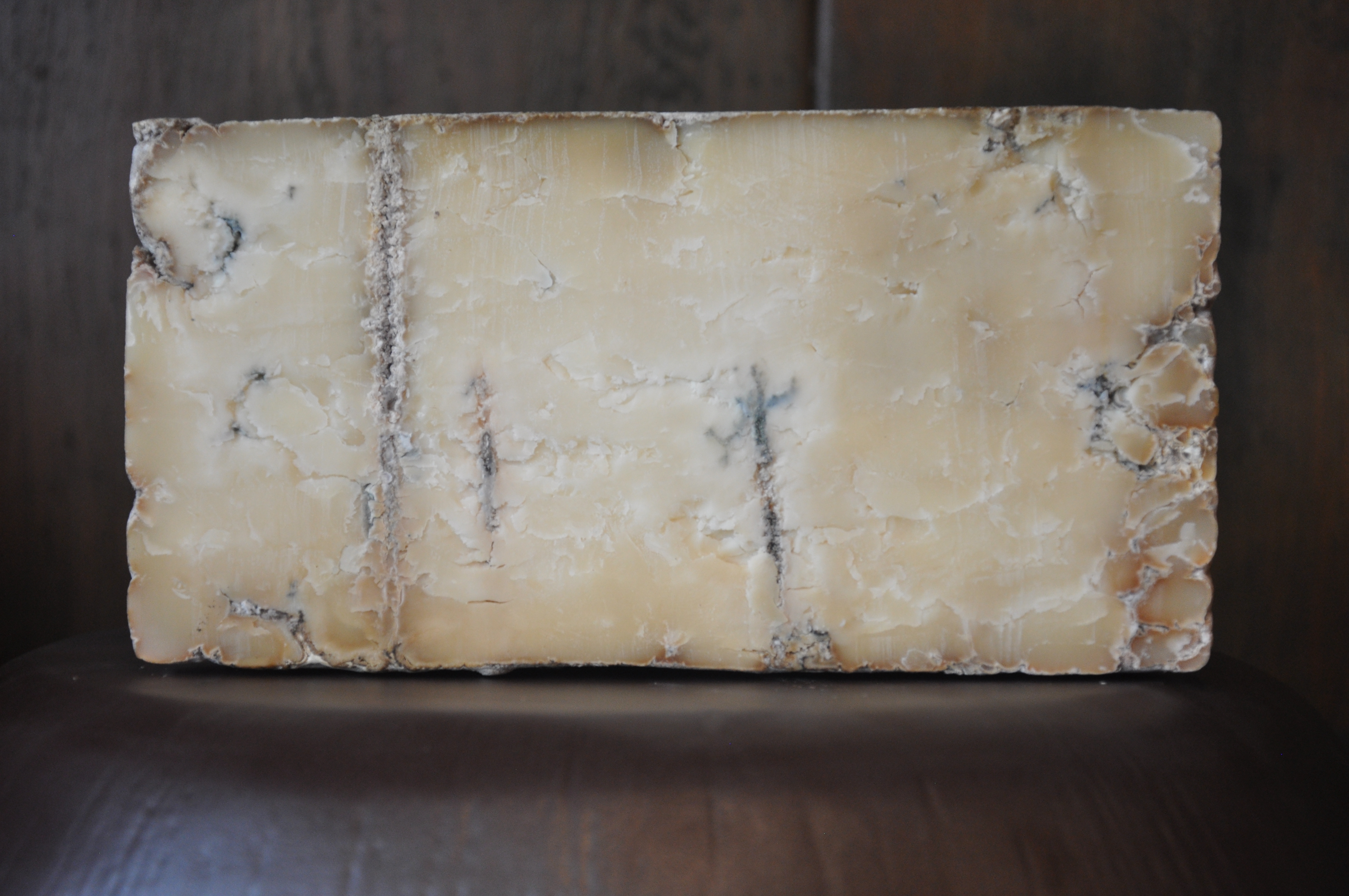 Wedge of Dunbarton Blue crumbly Wisconsin cheese on slate